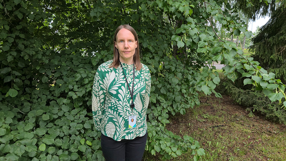 Kuvassa henkilöstöpäällikkömme Johanna ulkona lehtipuiden edessä.